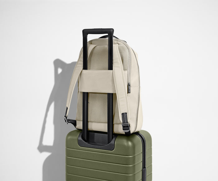 Back view of the Everywhere Zip Backpack sitting on top of an Away suitcase