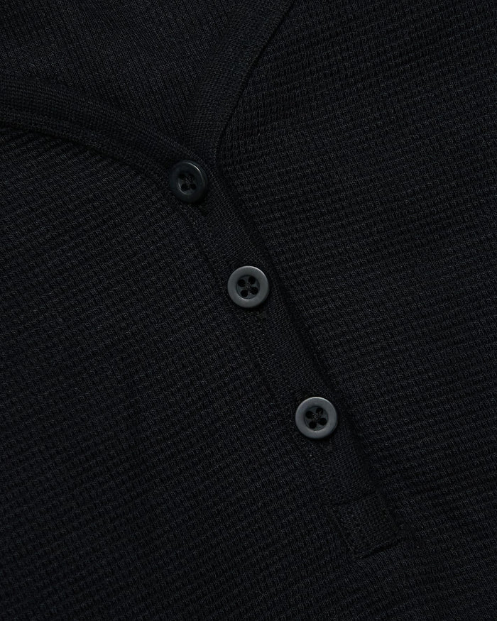 Close-up of Womens Black Waffle Long Sleeve Boxy Henley's button placket.