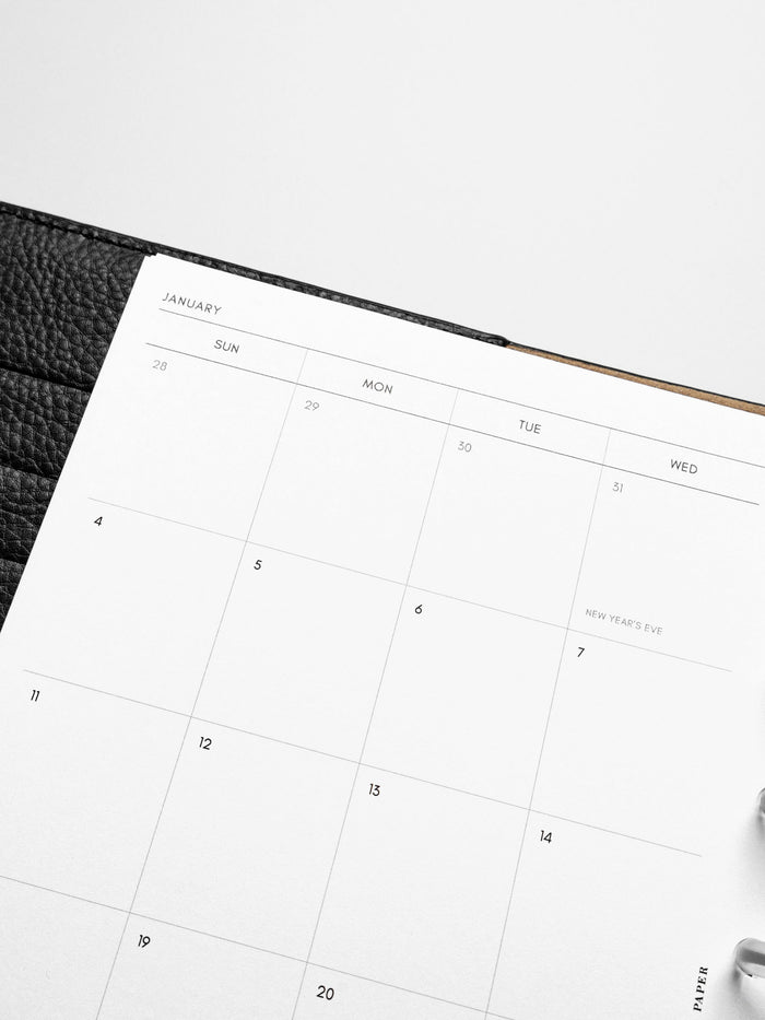 Images shows the Sunday Start 2026 Dated Monthly Planner Inserts in a black leather disc-bound planner.