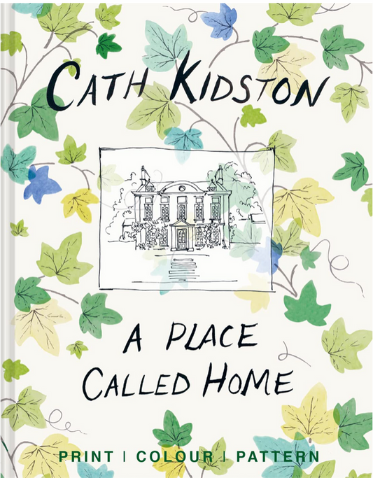 Front cover of book with white background; Sketch in black of large building with multiple window, walkway up to front door, and trees surrounding house in small black square in middle of cover; "CATH KIDSTON" in large black print at top of cover, above square, and "A PLACE CALLED HOME" below, all in black; Bottom of cover reads "PRINT, COLOR, PATTERN" in green text; Rest of cover depicts small brown stems with leaves in shades of green, blue, an yellow twisting all around on white background