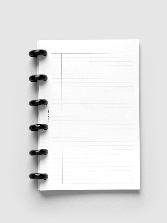 Aluminum Planner Discs | Black, 0.75 Inch, installed on a discbound planner showing lined paper pages with a narrow margin column, front view