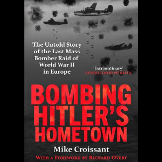 Book cover of 'Bombing Hitler's Hometown' with a black and white aerial view of planes and bombs.