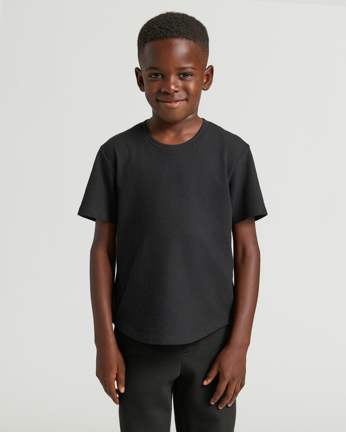 Boy wearing Boys' Black Classic Curved Hem Crew Neck, standing with relaxed arms.