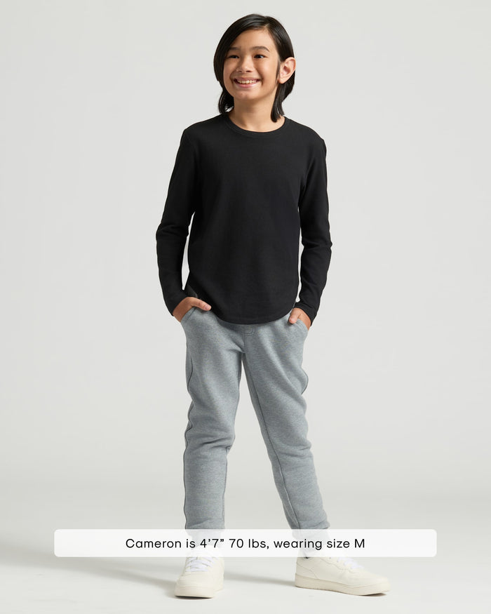 Grade-schooler in Boys' Black Classic Long Sleeve Curved Hem Crew and jogger pants.