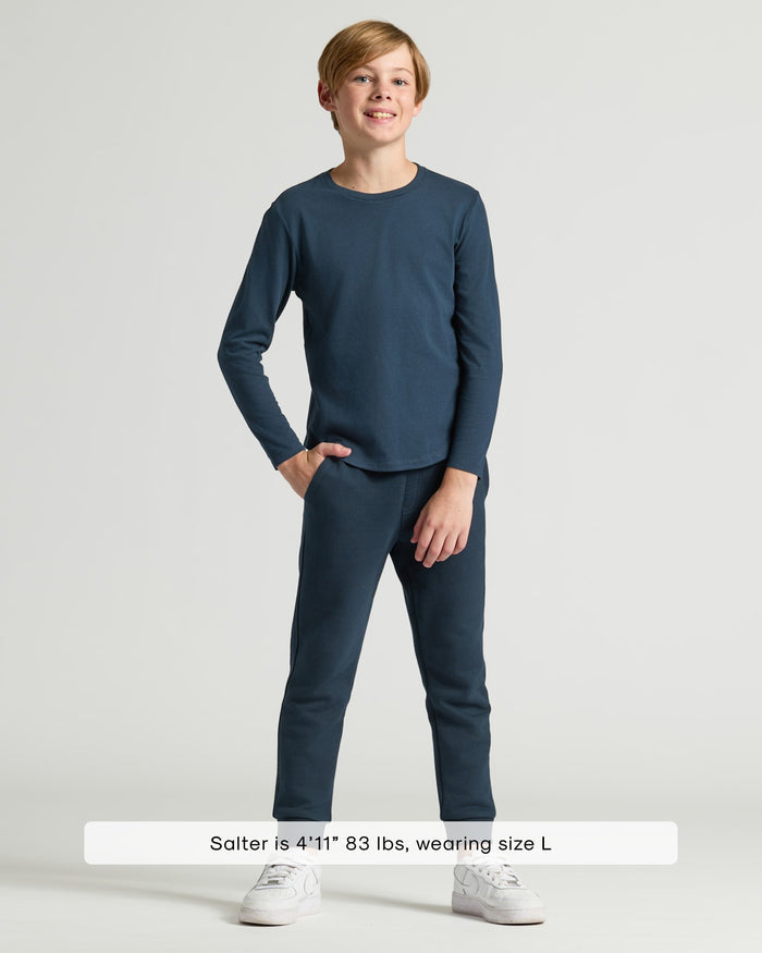 Boy wearing Boys' Navy Classic Long Sleeve Curved Hem Crew with joggers.