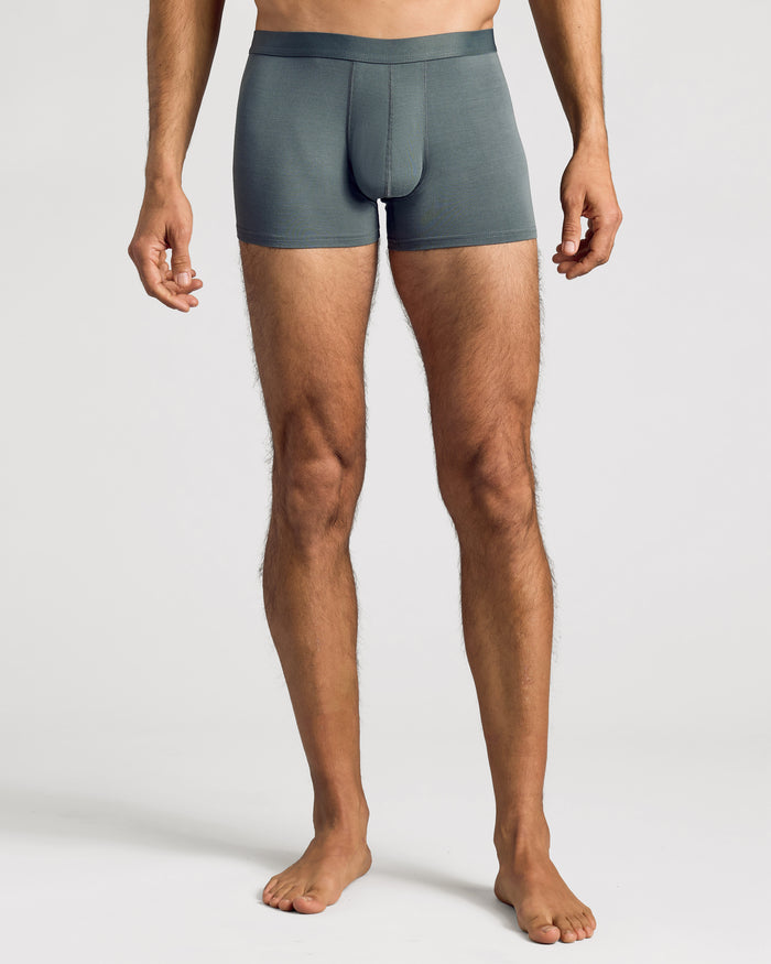 Man wearing Carbon Boxer Trunks 12-Pack, showcasing mid-thigh length and fitted design.