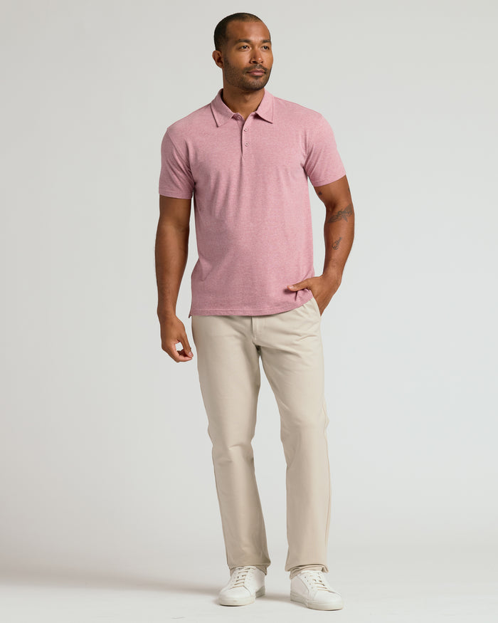 Model in Light Heather Boysenberry Classic Polo with tattoos, beige pants, sneakers.