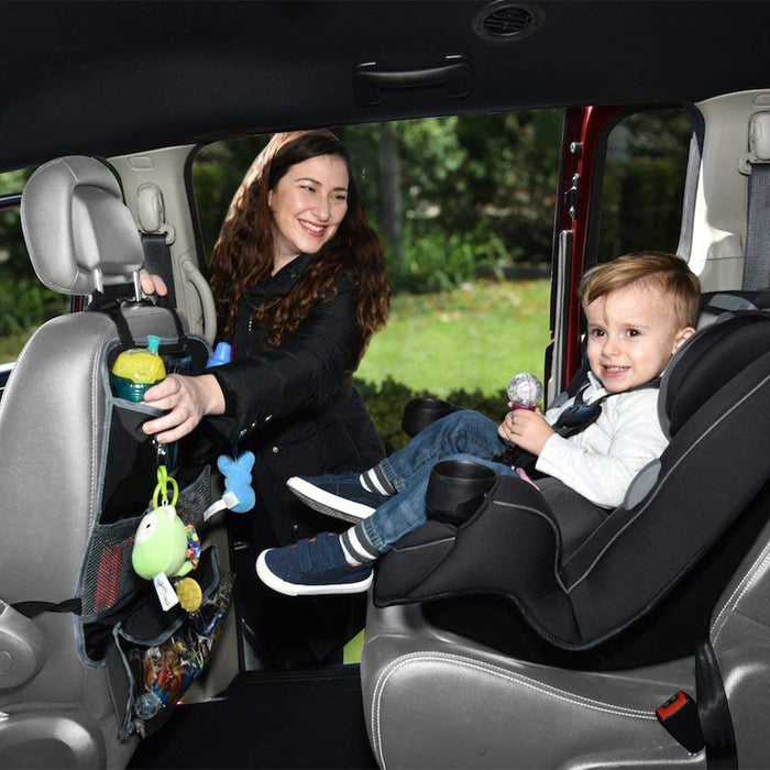 A woman smiles at a young child in a rear-facing car seat, with toys and essentials stored in the Nuby Deluxe Back Seat Organizer—the ideal car storage solution for baby travel needs.