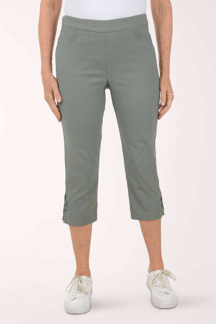 Person wearing green capri pants on a white background