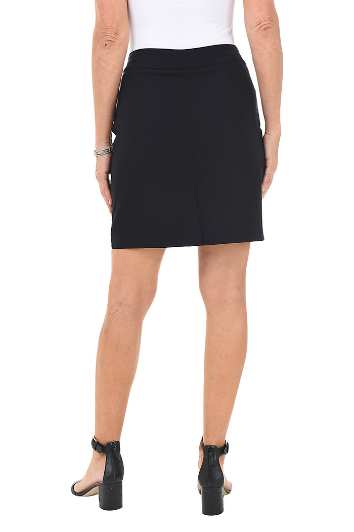 A back shot of a model wearing a black pull-on skort with dual front pockets, paired with a white top and black heels.