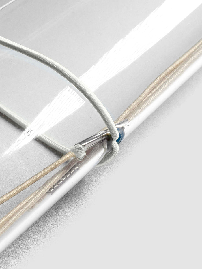 Grey elastic exterior band looped through clear vinyl travel cover spine.
