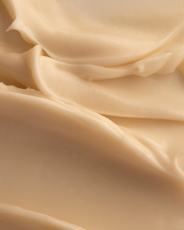 Close-up texture of smooth, creamy skincare product representing Firm Believer Goji Stem Cell + Pomegranate Smoothing Neck + Face Cream | Three Ships.