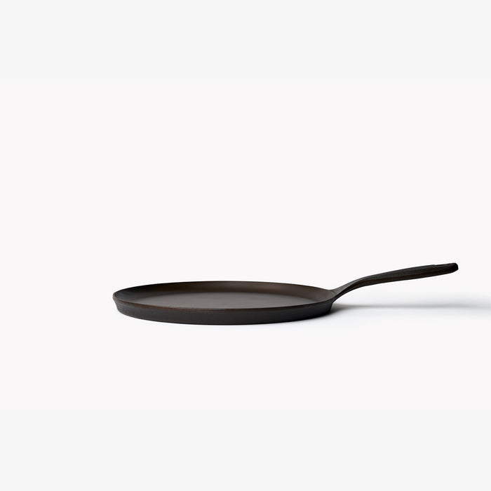Side view of the No.9 Field Round Cast Iron Griddle showing its low profile and gently curved handle