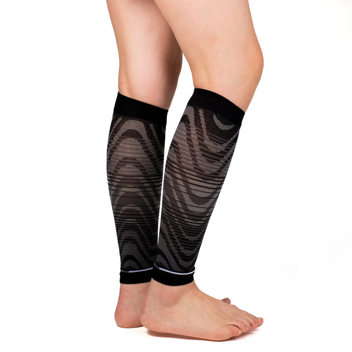 Black compression calf sleeves with an ombre wave pattern, worn on bare legs.