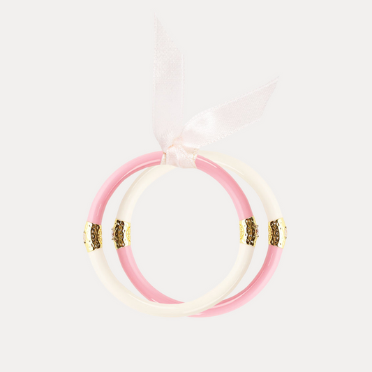 a pink and white bracelet with a ribbon