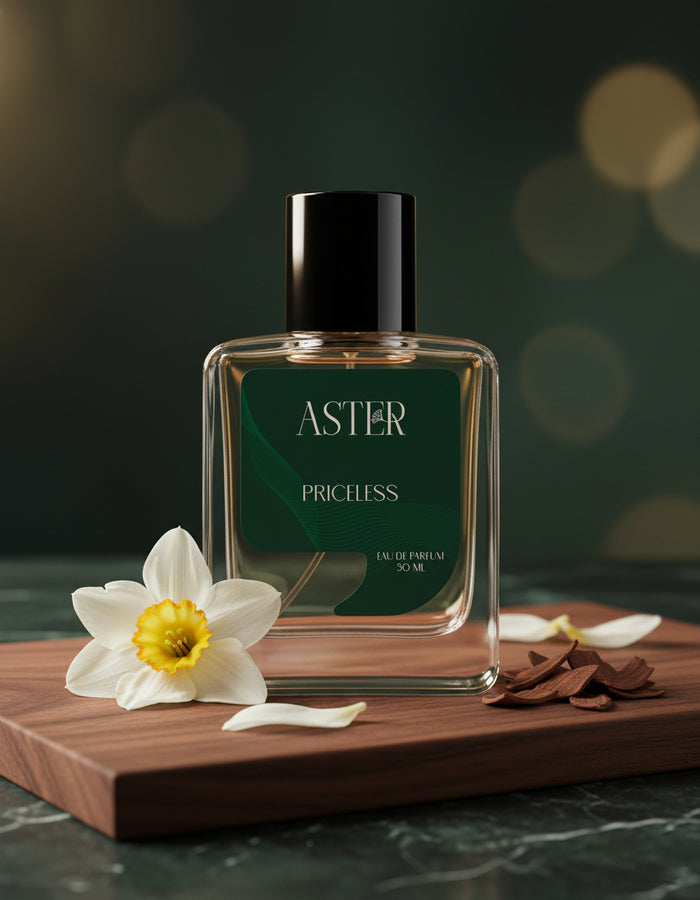 Perfume bottle labeled 'Aster Priceless' with flowers on a wooden board