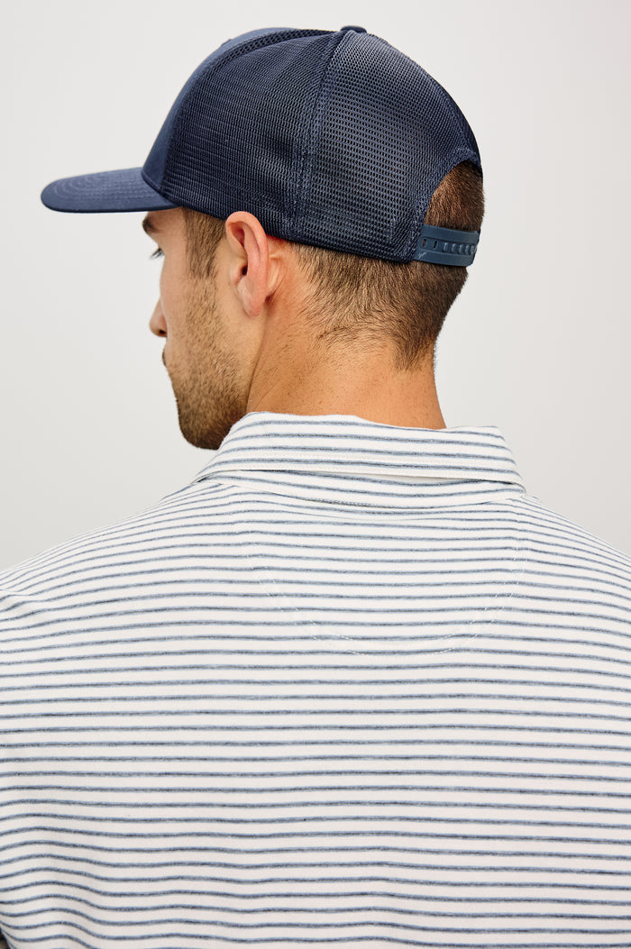 Golf Hat With Embroidered Branded Patch at Front, Adjustable Snapback, Mesh Back, and 6-Panel Construction in Navy Colorway - Upper Body Back View Featured on Model