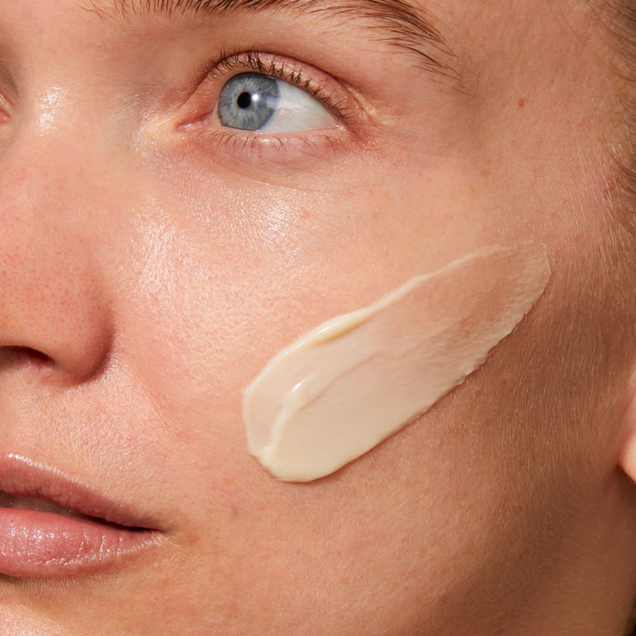 Close-up of a woman’s face with a smooth, creamy application of Rejuvenating Night Cream | Omorovicza on her cheek, highlighting skincare and hydration benefits.