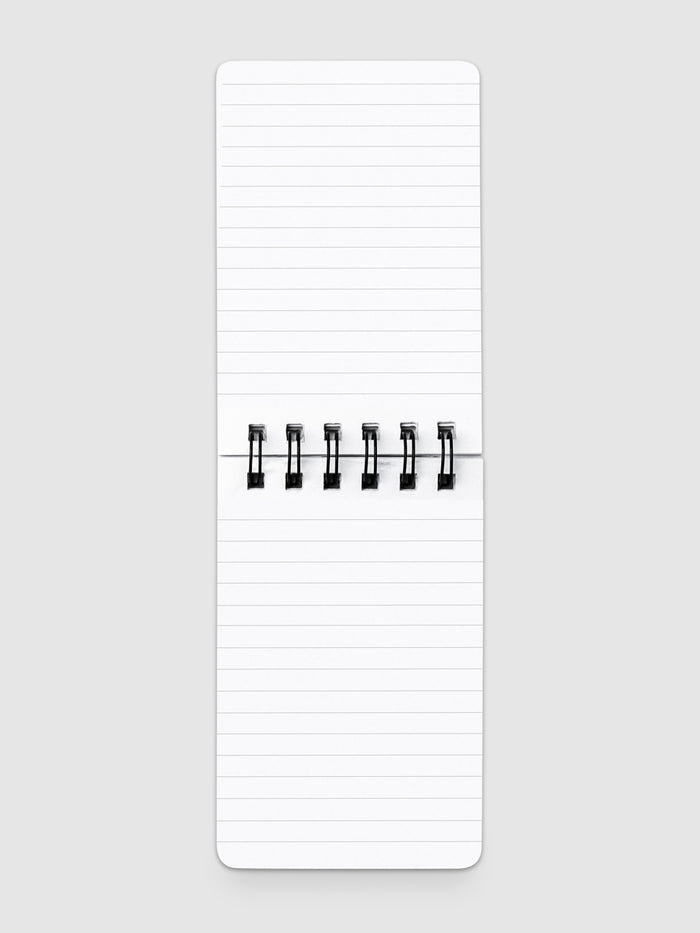 Lined notepad open on a neutral background.