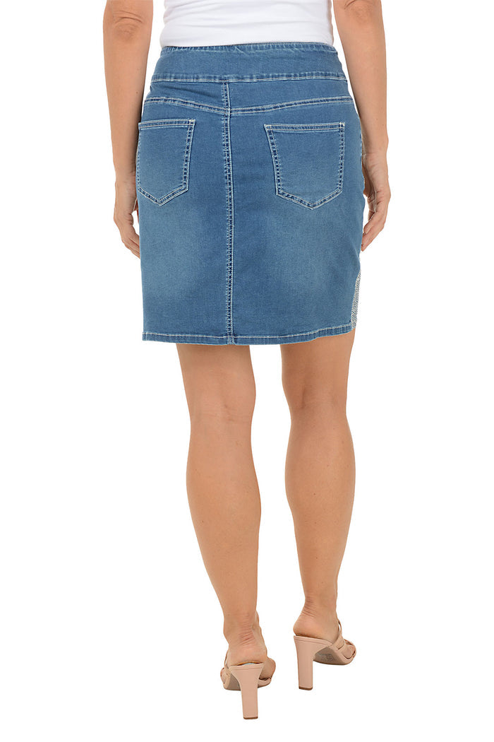 Blue denim skirt with contoured side panels bejeweled with glittery rhinestones worn by a person on a white background. Back shot.
