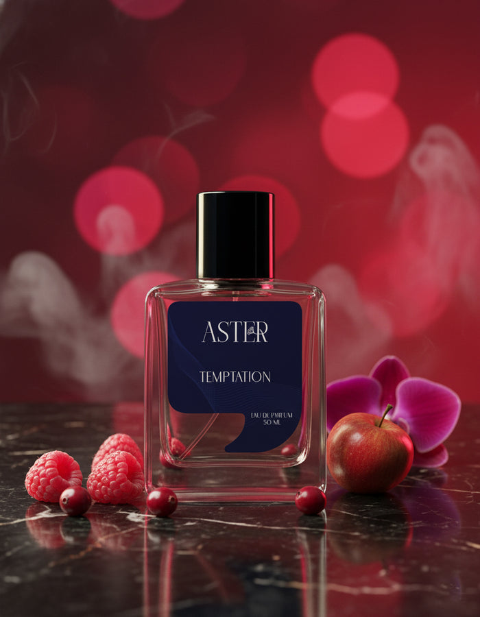 Perfume bottle labeled 'Aster' with berries and flowers on a dark surface with a blurred red background