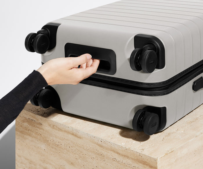 The Bigger Carry-On suitcase in Cloud Gray shown from below highlighting the underside grab handle
// 
Underside grab handle that makes it easier to lift and carry your suitcase.