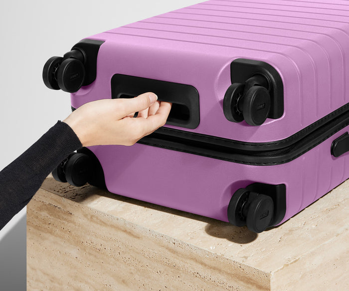 The Bigger Carry-On | Taffy Purple
// Underside grab handle that makes it easier to lift and carry your suitcase.