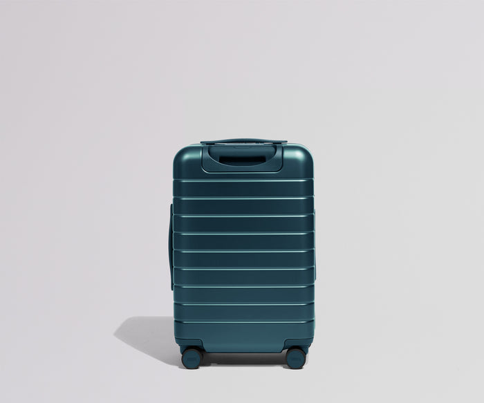 Teal suitcase on a light gray background
