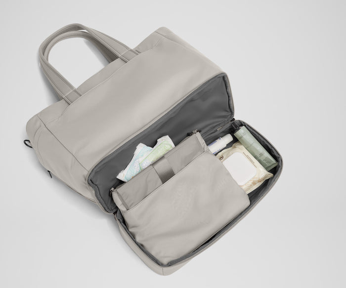 Bottom compartment shown with the included changing pad and Carry-All pouch that fits diapers and wipes