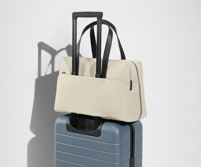 The Everywhere Bag secured to an Away suitcase by its trolley sleeve
// Our Everywhere Bags are designed with a trolley sleeve that slides onto your suitcase to keep it in place while you’re on the move. Paired with The Bigger Carry-On.