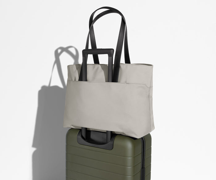 Everywhere Tote secured to an Away suitcase by its trolley sleeve