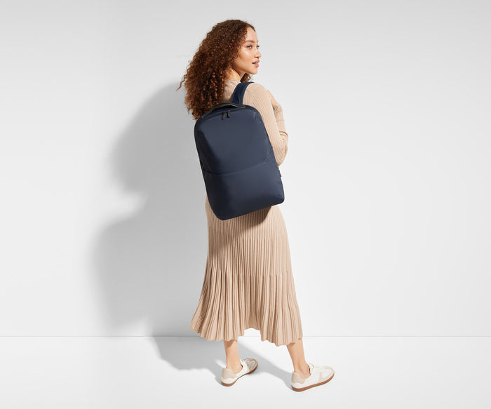 5'9" person wearing a Navy Blue Everywhere Zip Backpack on one shoulder
// Model is 5’9”