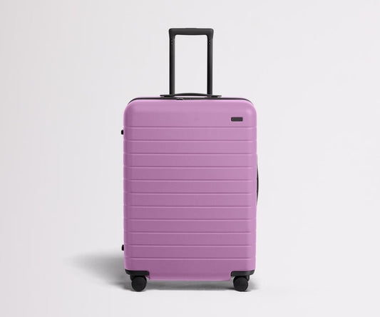 Front product view of The Medium suitcase in Taffy Purple with raised handle