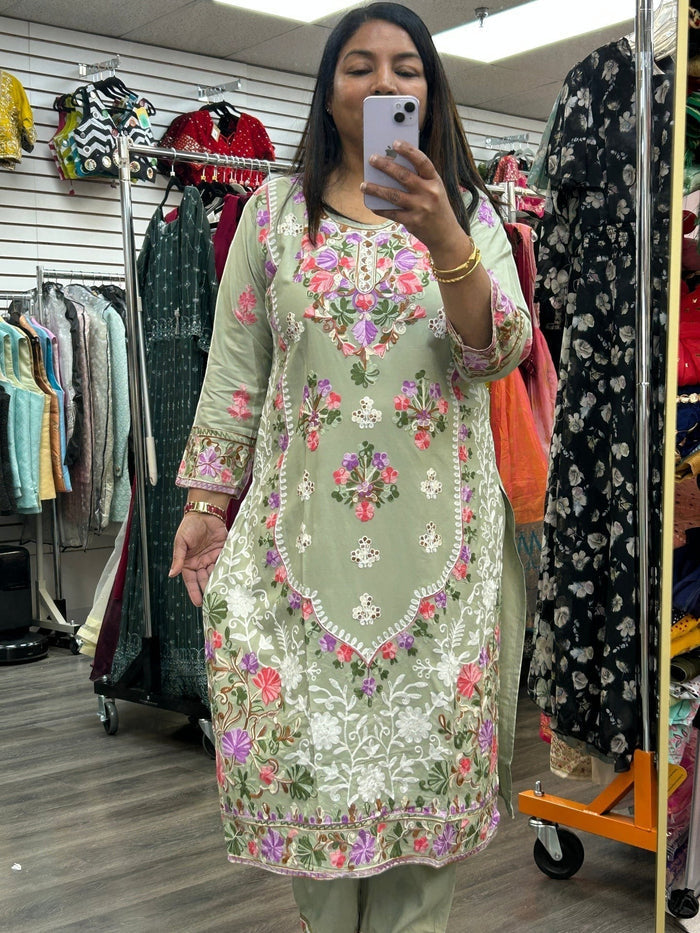 Kurti Connection USA sage green kurti set featuring intricate multi-colored floral embroidery on the front and sleeves.