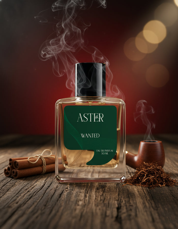 Aster Wanted perfume bottle with cinnamon sticks and a smoking pipe on a wooden surface.