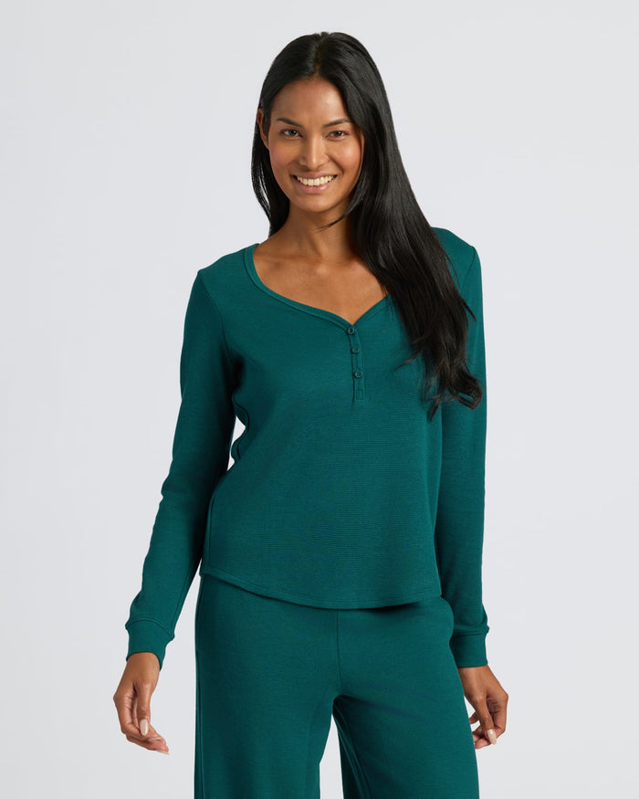 Woman wearing Women's Deep Emerald Waffle Long Sleeve Boxy Henley, smiling. MODEL_INFO: Candy is 5'9", wearing a size S