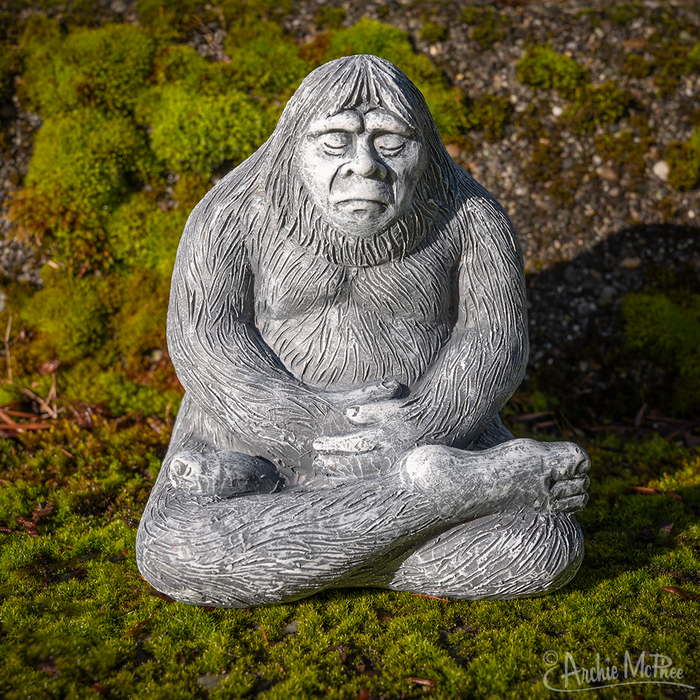 The Zen Bigfoot evokes tranquility as it peacefully meditates on a lush bed of green moss, crafted from durable polystone – an ideal addition to enhance serenity in your garden.